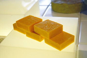 Several bars of orange solid soap, handmade using traditional technology from natural ingredients. A close-up photograph of an exhibit from the Soap Museum in Gaziantep, Turkey (Türkiye)