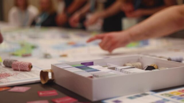 Process of playing tabletop board game on the table, fun with friends and family in room indoors, board game concept, company group of students adults play board games, roll the dice on a game map