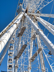 Liverpool, Albert dock. Low-angle view of a white Ferris wheel structure against a clear blue sky.