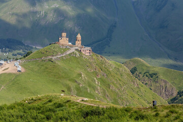 breathtaking view of a mountain range with a ancient Gergeti Trinity Church, under Mount Kazbek near the village of Stepantsminda in Georgia