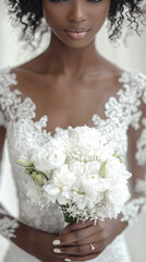 Naklejka premium Elegant bride holding a bouquet of white flowers is posing in her white lace wedding dress
