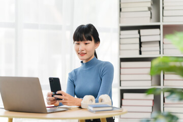 Focused and Connected: A young woman in a blue turtleneck, immersed in her work, seamlessly blends the digital world with the physical.