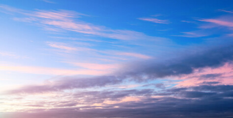 Sunset sky with pink and blue clouds, wide angle panoramic view of colorful sunset sky. Vast sunset sky landscape in picturesque tones