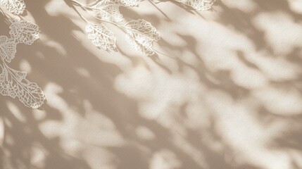 Delicate white leaves are casting beautiful artistic shadows on a smooth beige background, creating a serene and minimalist aesthetic