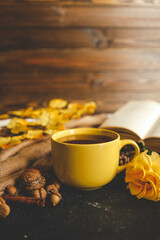Cozy autumn scene with tea, pastry, yellow roses, and warm knitted sweaters