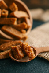Wooden bowl filled with crispy rye croutons placed on a burlap cloth, creating a rustic snack presentation