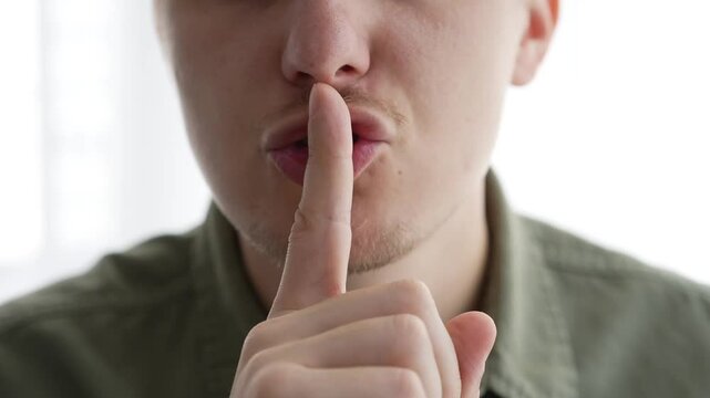 A man closes his mouth so as not to make sounds.
The man is trying not to talk.
Closed mouth.
Gesture of silence.
Complete silence.
Shut your mouth.
Don't say anything
