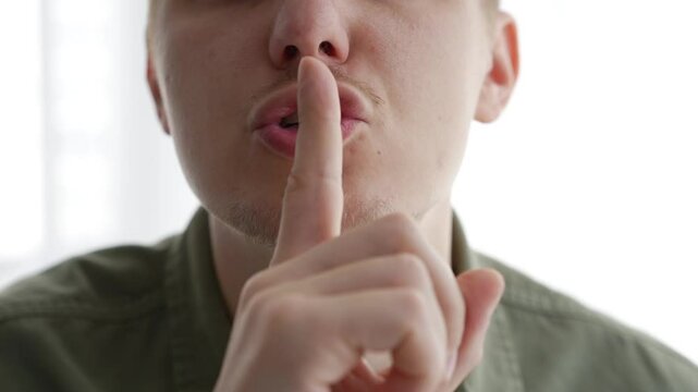 A man closes his mouth so as not to make sounds.
The man is trying not to talk.
Closed mouth.
Gesture of silence.
Complete silence.
Shut your mouth.
Don't say anything