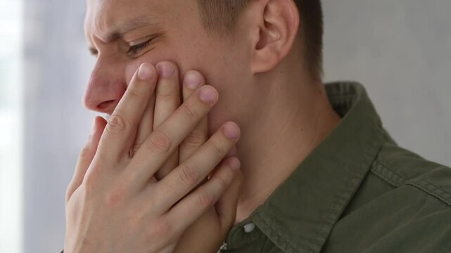 A man is suffering from toothache.
A person has a toothache.
Dental problems.
A man holds his cheek with his hand and suffers from toothache.
Going to the dentist.
Treatment of caries.
Dental office