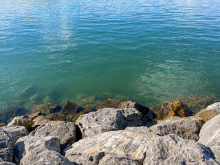 PLAYA. COSTA. ROCAS JUNTO AL MAR. EL MAR ES DE COLOR AZUL VERDOSO. CONTRASTE DE LAR ROCAS CON EL AGUA DEL MAR.