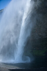 The waterfall of Seljalandsfoss in Iceland from behind the water