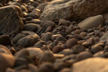 lake stones close up in sunset golden light - wallpaper background
