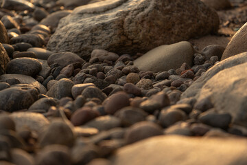 lake stones close up in sunset golden light - wallpaper background