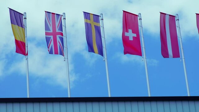national flags Europe and other countries on satin flutter in wind in blue sky, European Space Agency, state symbols, concept of international cooperation, global business