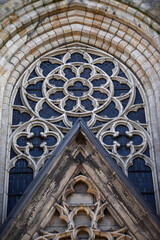 A gothic window closeup with an arch framing it and a rose window. German church of St. Urban in Gelsenkirchen. 