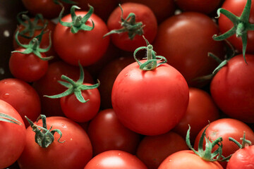 Tomatoes stacked on top of each other in a supermarket for sale, tomato texture.