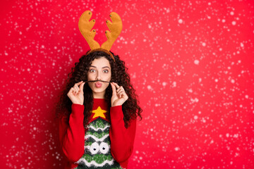 Photo of funny lady making moustache with one curl acting liked guy want win costume competition wear head horns pullover with green tree isolated red color background