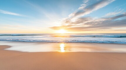 Fototapeta premium A breathtaking sunrise over a sandy beach with gentle waves crashing ashore. The sun's rays illuminate the sky with warm hues and reflect off the water's surface.