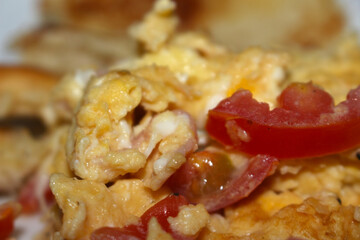 scrambled eggs with tomato. meal details. selective focus food. eggs prepared with tomato.