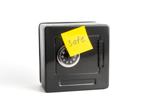 Small safe with combination lock and yellow sticky note