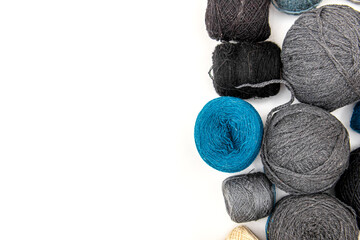 Black, gray and blue crochet yarns on white background. Wool yarn. Free space for text