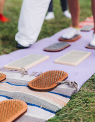 Standing on sadhu board, process of barefoot standing on nails therapy, view of legs feet on nails, yoga and sadhu practice, outdoor meditation with nailing practice, wooden nail board, summer day