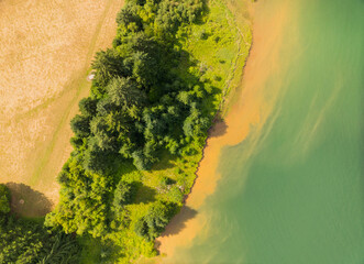 A green and brown area with trees and water