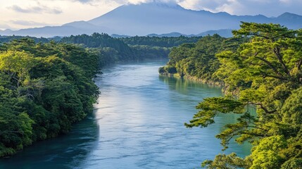 Obraz premium A serene river winds through a lush green valley, with majestic mountains rising in the background. The morning light casts a soft glow on the scene.