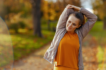 young 40 years old woman in fitness clothes in park stretching