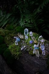 quartz crystals and amulet in forest, dark natural background. minerals for Magic Crystal Ritual,...