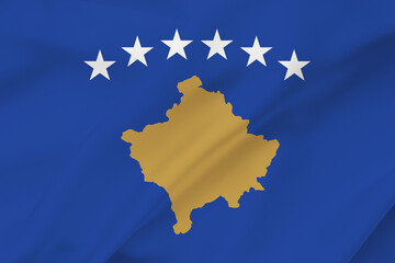 Kosovo flag on waving silk background. Fabric texture. National icon of Kosovo.