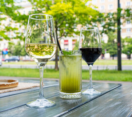 Red wine, herbal lemonade and white wine glasses on restaurant table. Family dinner in restaurant