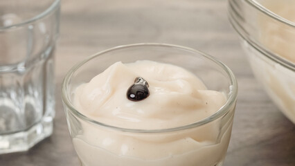 Topping vanilla pudding with chocolate sauce