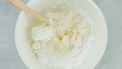 Cream cheese whipped cream recipe. Mixing cream cheese, sugar powder, and whipping cream together in a bowl. Close-up preparation process, recipe