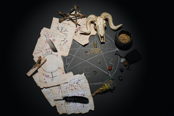 Witch's magic attributes with drawn pentagram on dark background