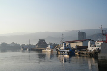Fototapeta premium Exploring the tranquil morning at Dili Ferry Harbor in Timor-Leste with boats dotting the calm waters