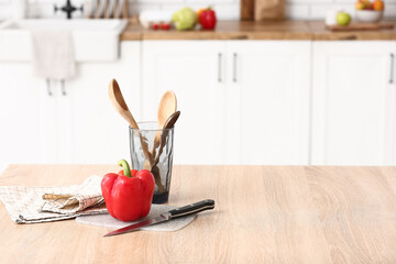 Cooking utensils and fresh bell pepper on table in kitchen
