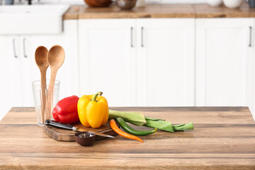 Cutting board with fresh vegetables on table in kitchen