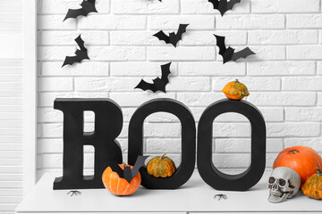 Word BOO with Halloween pumpkins, skull and paper bats on commode in room
