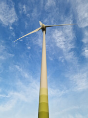 Wind Turbine in Rural Landscape Under Blue Sky