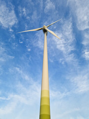 Wind Turbine in Rural Landscape Under Blue Sky