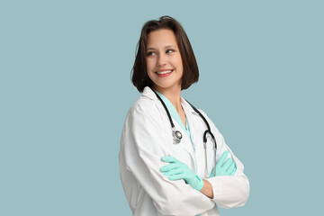 Beautiful female doctor with stethoscope on blue background