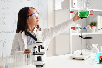 Cute little girl with scientific equipment in chemistry classroom