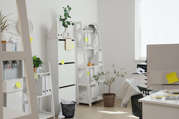 Interior of messy office with workplace, shelf units and sticky notes