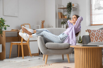 Young beautiful woman resting on armchair at home