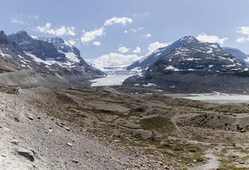 An expansive glacial valley displaying rugged landscapes and striking mountain ranges in the...