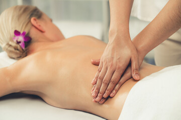 Fototapeta premium Caucasian woman customer enjoying relaxing anti-stress spa massage and pampering with beauty skin recreation leisure in day light ambient salon spa at luxury resort or hotel. Quiescent