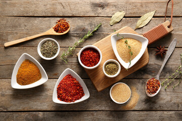 Composition with bowls of different aromatic spices on wooden background