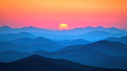 Fototapeta premium A vibrant sunset over a mountain range with layers of blue hues and a bright yellow sun.