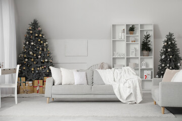 Interior of stylish living room with grey sofas, Christmas trees and gift boxes